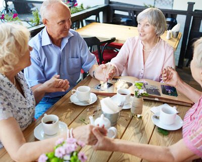 seniors-holding-hands-cafe-2