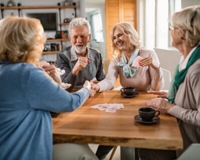 happy-senior-women-handshaking-after-playing-cards-with-their-friends-home
