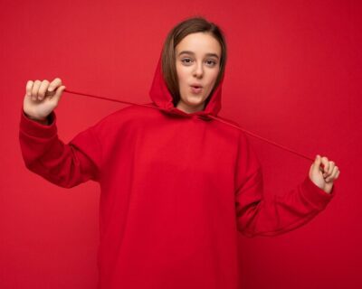 photo-shot-beautiful-surprised-happy-smiling-brunette-female-teenager-wearing-trendy-red-hoodie_88135-32092