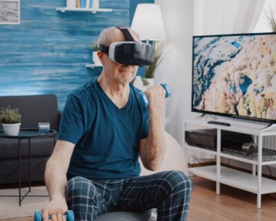 pensioner-using-vr-glasses-physical-exercise-with-dumbbells-while-sitting-fitness-toning-ball-senior-person-with-virtual-reality-goggles-training-arms-muscles-with-weights_482257-28314
