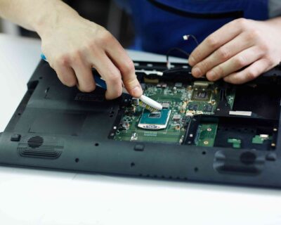 technician-clearing-circuit-board-disassembled-laptop-3-1