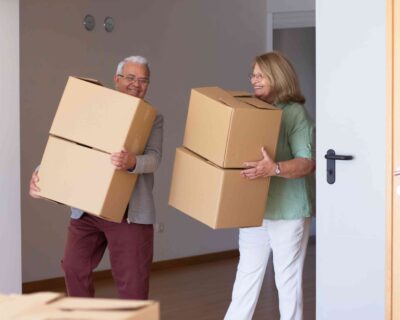smiling-elderly-couple-moving-into-new-house-retired-husband-wife-holding-cardboard-boxes-carrying-things-real-estate-purchase-moving-concept-2