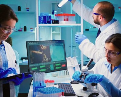 team-positive-scientists-working-chemistry-equipped-laboratory-nurse-typing-tablet-1