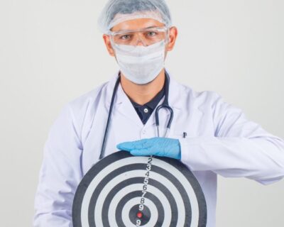 male-doctor-holding-dartboard-protective-clothes-looking-careful-90kb